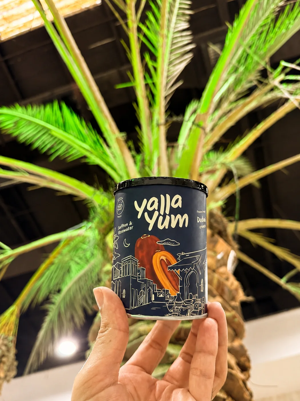 Saffron and Rosewater Dubai Crunch can held beneath a date palm
